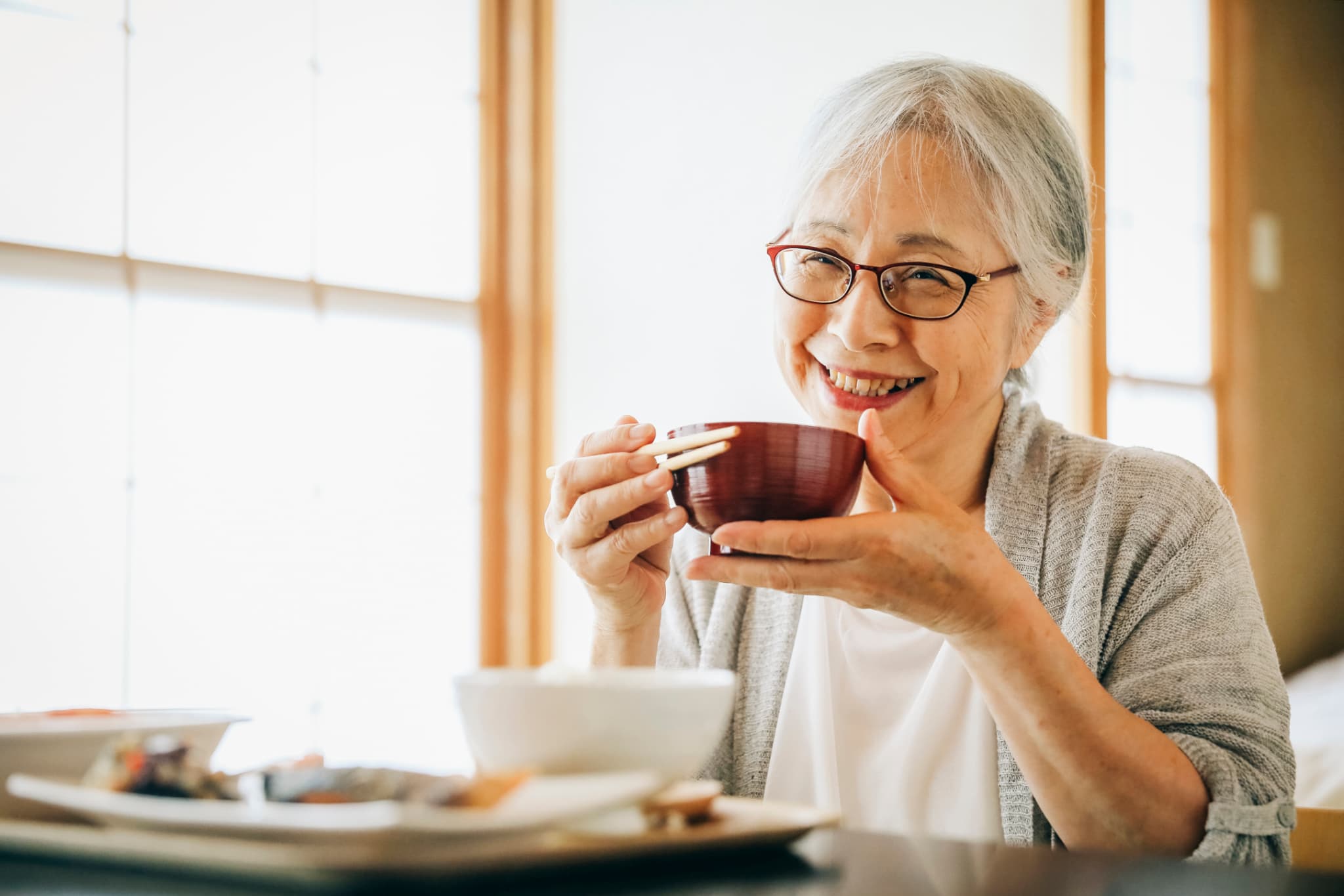 自分に合った入れ歯で快適に食事をする高齢女性