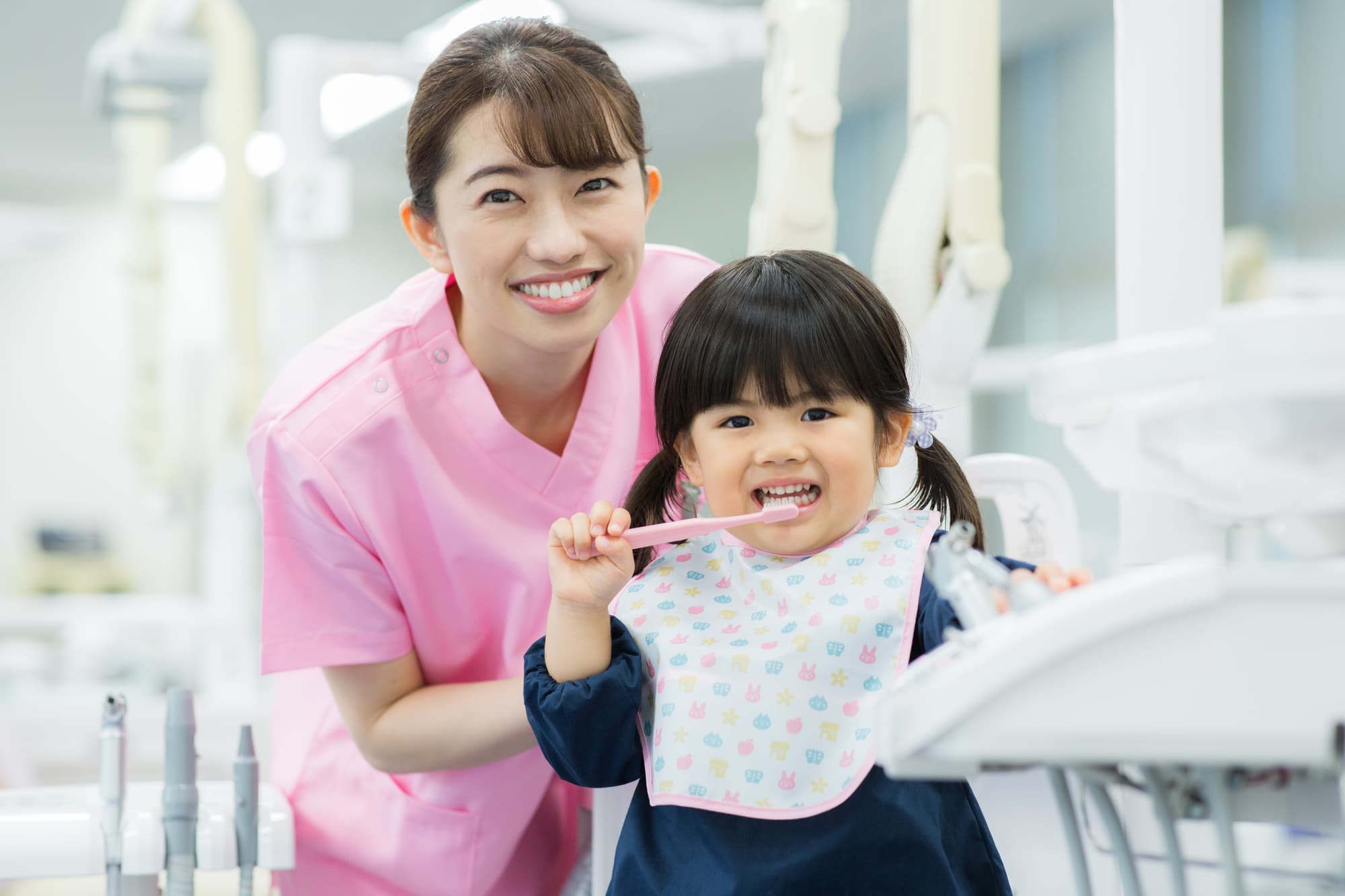 予防歯科でブラッシング指導をする歯科衛生士と子ども