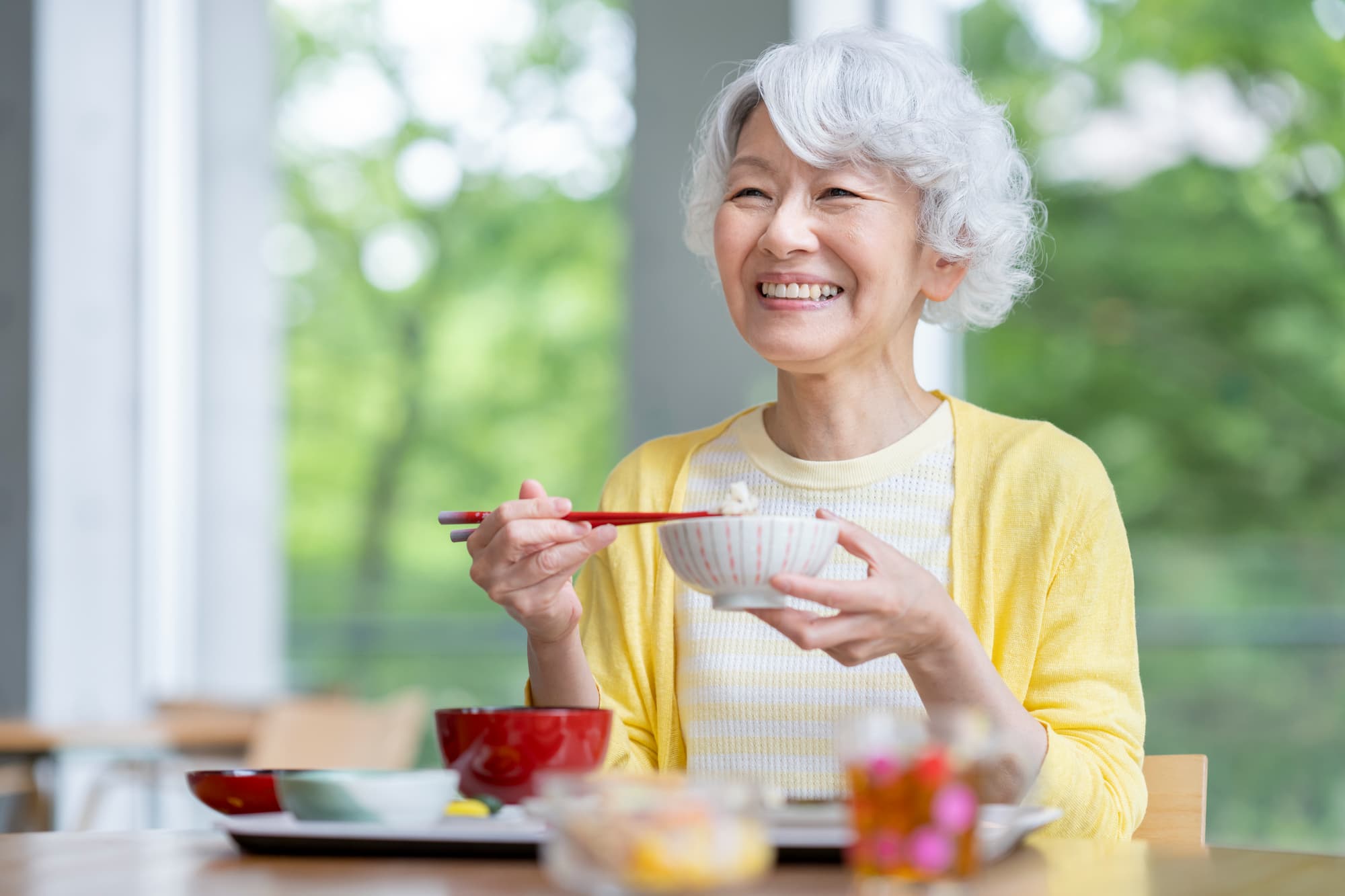 自分に合った入れ歯で美味しく食事をいただく女性