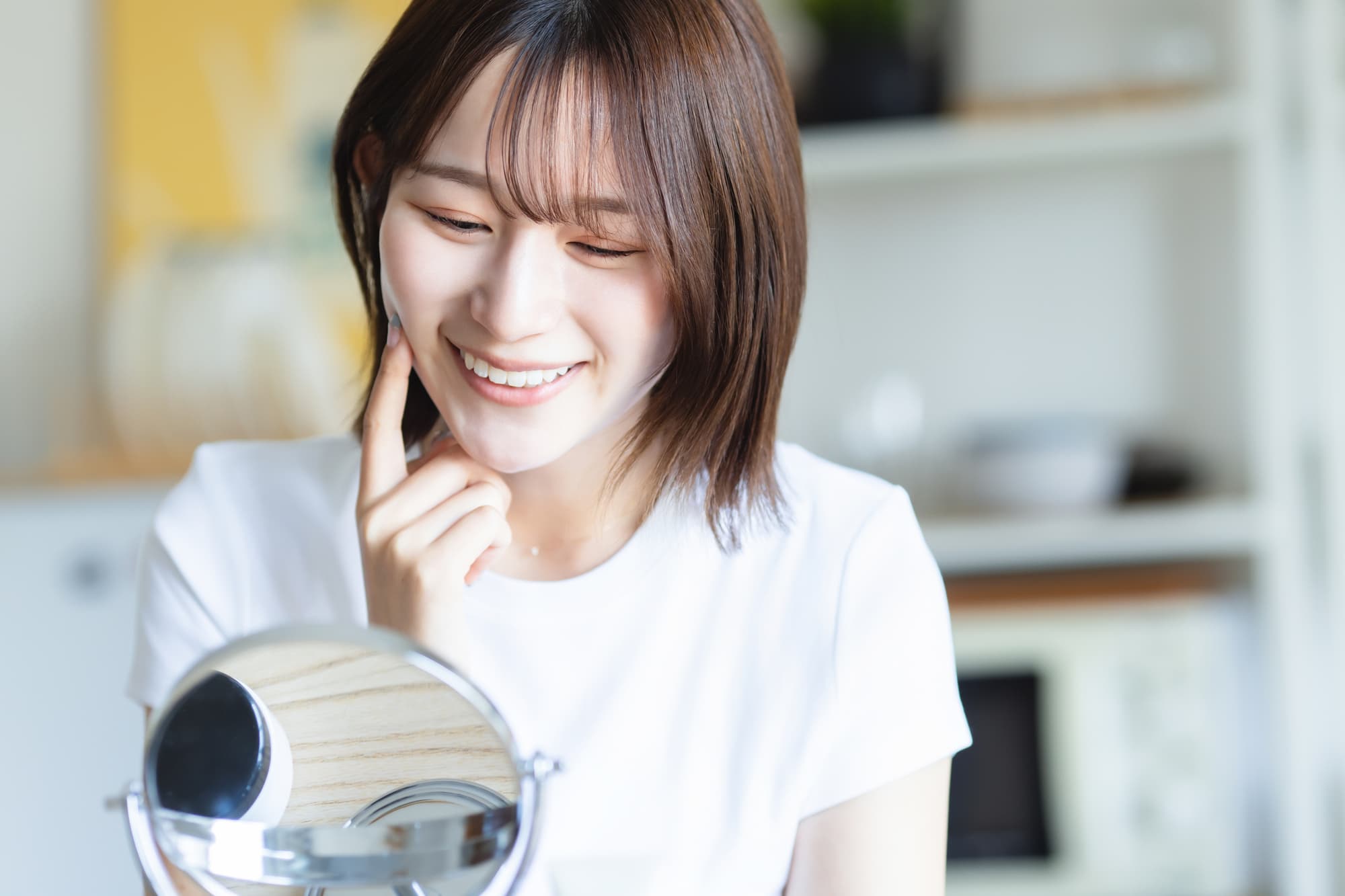 ラミネートニベアで治療した歯を鏡で確認する女性