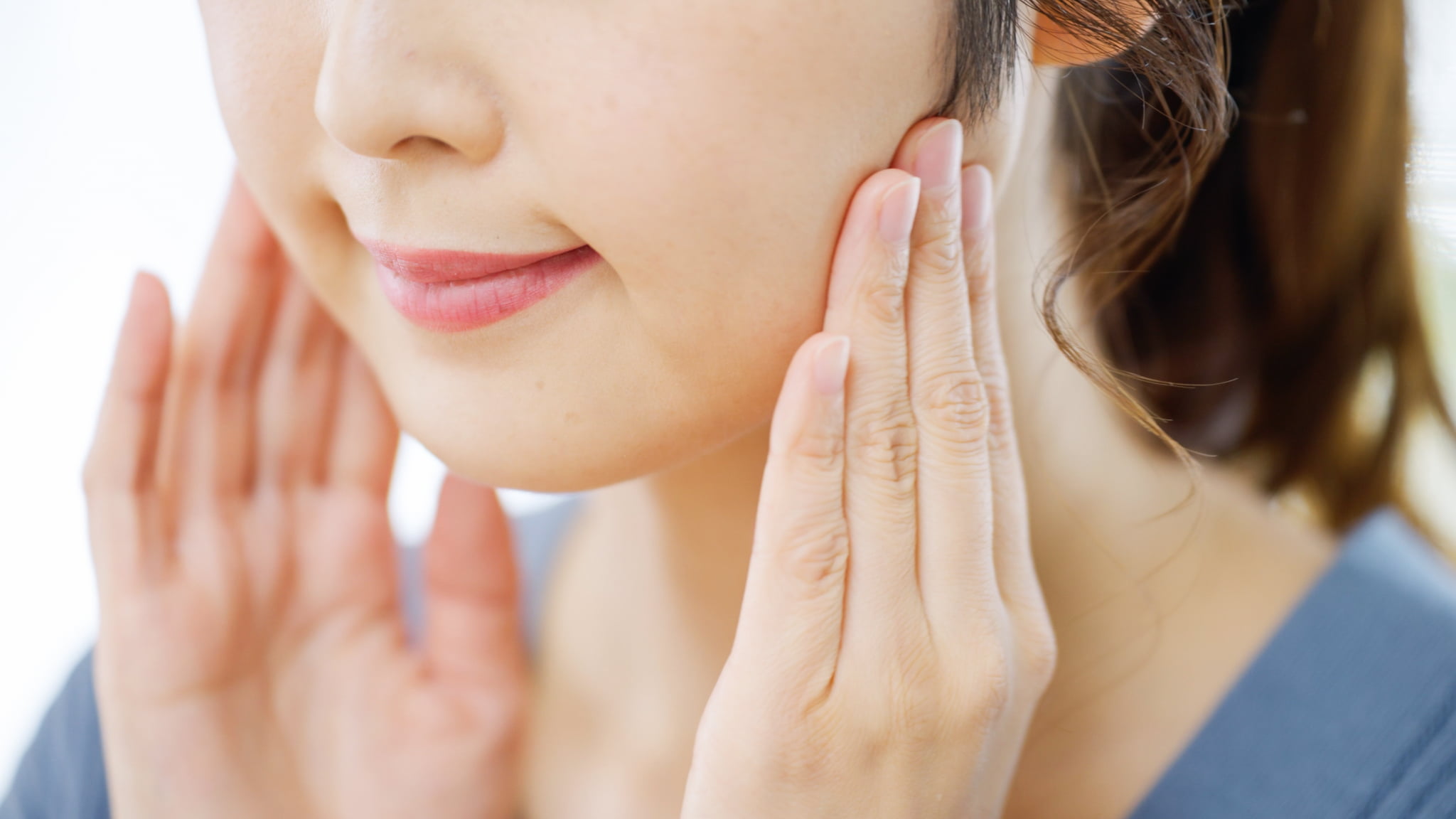 顎関節症の治療でマッサージをする女性