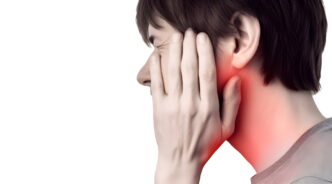 顎関節症で痛む顎を手でおさえる男性