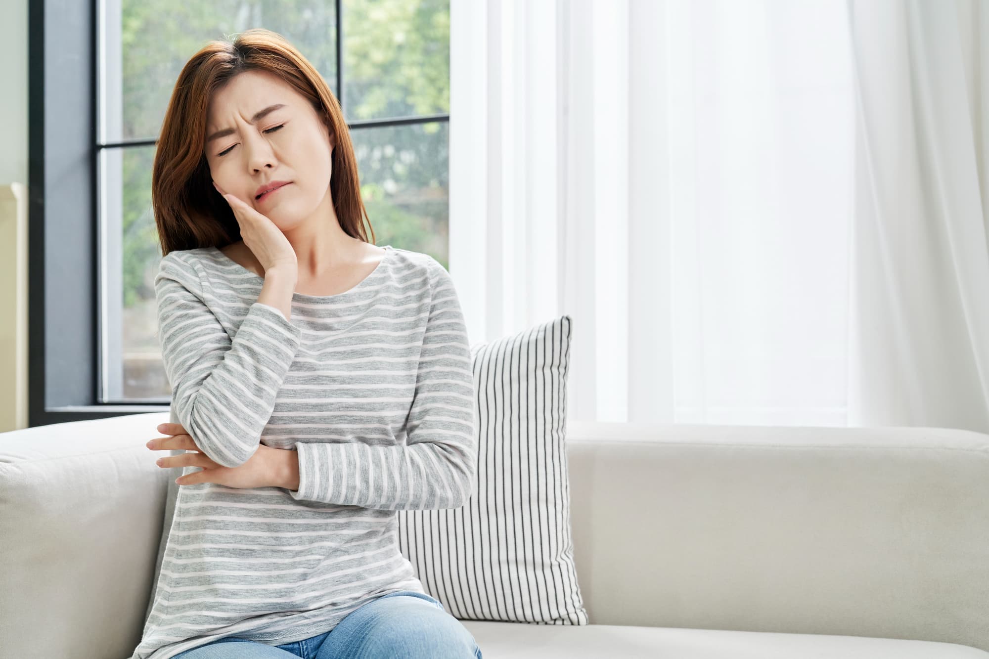 根管治療後に痛みを感じる女性