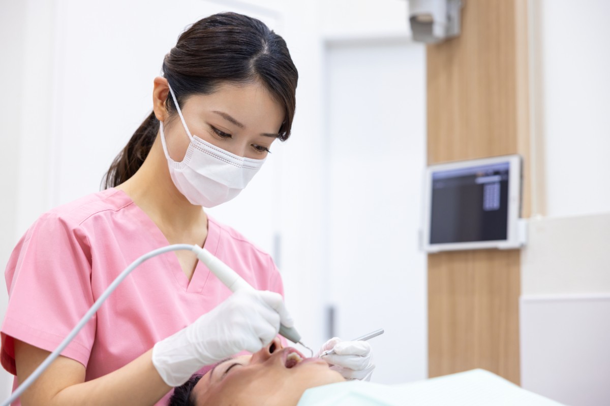 歯石取り治療をしている女性歯科医師