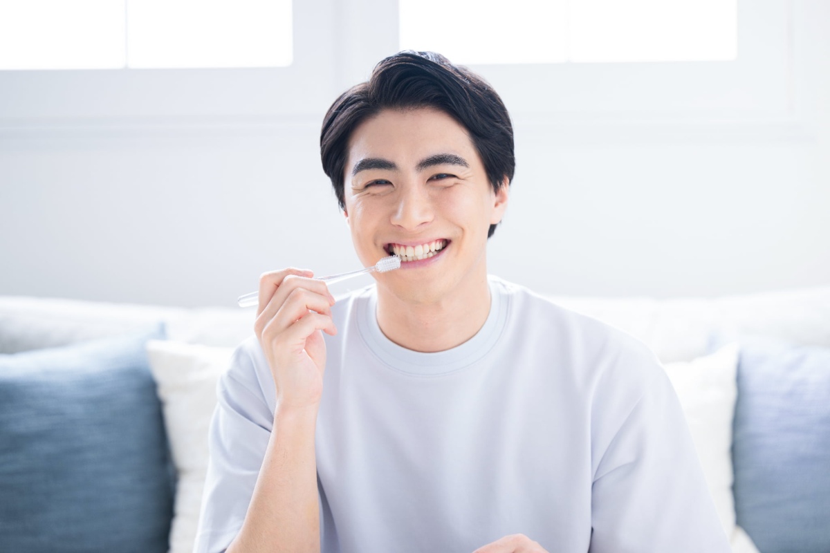 根管治療を計画どおりに進める為に歯みがきで口腔内を清潔にする男性